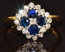 An 18ct gold ring set with four round cut sapphires surrounded by diamonds, 4.5g, size N