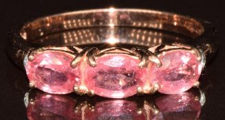 A 9k gold ring set with three oval cut Padparadscha sapphires, the total carat weight 1.3ct, and two