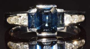 A 14k white gold ring set with three emerald cut sapphires and six round cut diamonds, 3.7g, size N