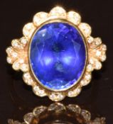 An 18ct gold ring set with an oval cut tanzanite of approximately 10ct surrounded by diamonds, total
