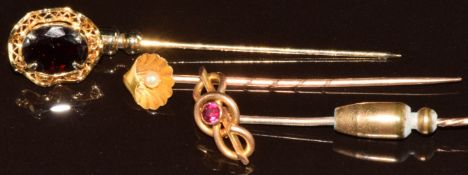 Two 15ct gold stick pins, one set with a ruby and the other a shell set with a pearl, and a 14k