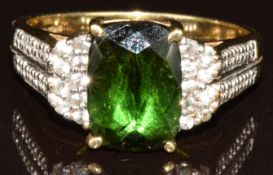 A 9k gold ring set with a fancy cut olive tourmaline of approximately 3.3ct, white sapphires and