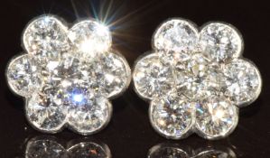 A pair of c1930s earrings each set with seven round cut diamonds, the total carat weight