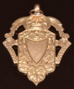 A 9ct rose gold fob in the shape of a shield with engraved floral decoration, 5.6g