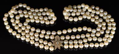 A double strand of cultured pearls with a Victorian yellow metal pendant in the form of a flower set