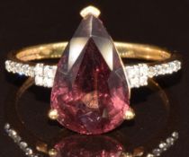 An 18k gold ring set with a pear cut colour change garnet of approximately 5ct and diamonds, with