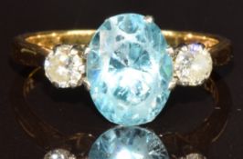 An 18ct gold ring set with an oval cut zircon of approximately 1.6ct and two round cut diamonds,