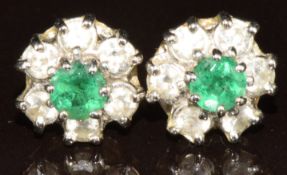 A pair of 18ct white gold earrings each set with a round cut emerald of approximately 0.2ct