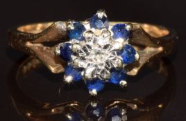 A 9ct gold ring set with a diamond surrounded by sapphires, 3.4g, size N