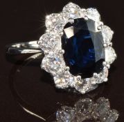 An 18ct white gold ring set with an oval cut sapphire of approximately 2.5ct surrounded by ten round