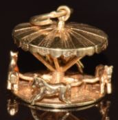A 9ct gold charm/ pendant in the form of a moving fairground carousel, 7.7g