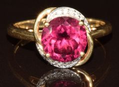 A 14k gold ring set with a round cut umbalite of approximately 3.5ct surrounded by diamonds, with