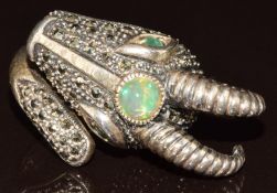 A silver ring in the form of an an antelope set with white opal, emerald and marcasite, 12.4g,