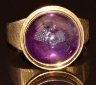 An 18ct gold ring set with an amethyst cabochon, with Swiss hallmarks, 6.2g, size L