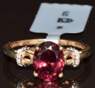 A 9k gold ring set with an oval cut Umba River garnet and white zircons, with Gemporia