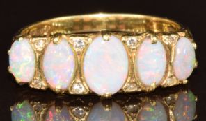 An 18ct gold ring set with five oval opal cabochons and eight diamonds, 5.2g, size Q
