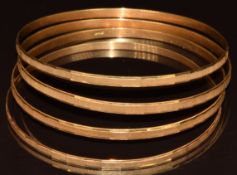 Four 18ct gold Italian bangles with textured decoration, 29.6g