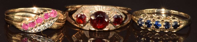 Three 9ct gold rings, one set with rubies and diamonds, one garnets and the other with sapphires,