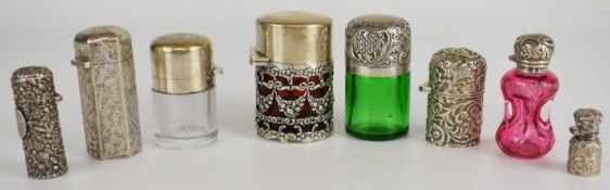 Eight hallmarked silver / white metal mounted scent/perfume bottles including coloured glass