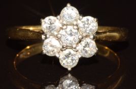 An 18ct gold ring set with seven round cut diamonds in a cluster, the total approximately 0.7ct, 3.