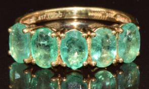 A 9k gold ring set with five oval cut Zambian emeralds totalling approximately 1.8ct and four