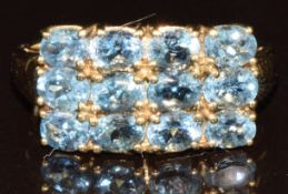 A 9k gold ring set with twelve oval cut Santa Maria aquamarines, the total carat weight
