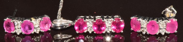 A 14k white gold pendant set with three oval cut rubies and diamonds, on 14k white gold chain,