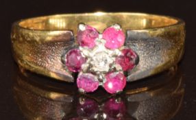 An 18ct gold ring set with a diamond surrounded by rubies in a cluster, 3.4g, size K