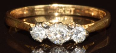 An 18ct gold ring set with three round cut diamonds, the centre diamond approximately 0.2ct, 2.7g,