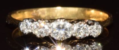 An 18ct gold ring set with five diamonds, the centre diamond approximately 0.14ct, 2.5g, size O