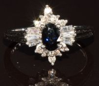 A 9k white gold ring set with an oval cut sapphire of approximately 0.45ct surrounded by round and