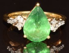 An 18k gold ring set with a pear cut tsavorite garnet of approximately 3.2ct, twelve round cut