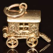 A 9ct gold charm in the form of a caravan opening to reveal a fortune teller, 3.4g