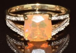 A 9k gold ring set with a cushion cut Indonesian opal of approximately 1.1ct and zircons, with