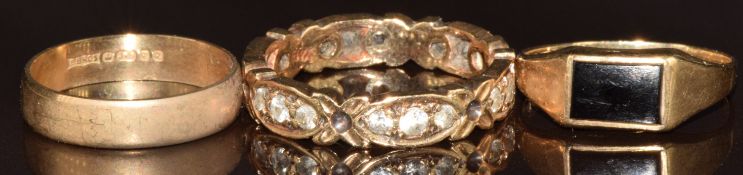 Three 9ct gold rings, one set with onyx, one an eternity ring set with spinel and one a wedding