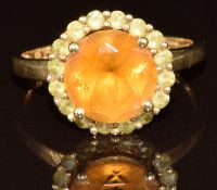 A 9k gold ring set with a citrine surrounded by peridot, 3.2g, size T