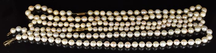Two single strands of cultured pearls with 9k gold clasps and a single strand of cultured pearls