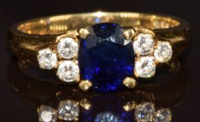 An 18ct gold ring set with an oval cut sapphire of approximately 0.75ct and six diamonds, 3.7g, size