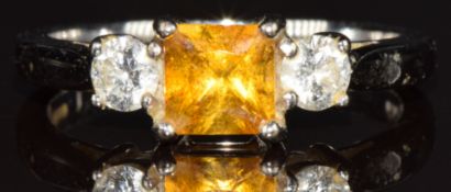 An 18ct white gold ring set with a princess cut yellow sapphire and two round cut diamonds, each