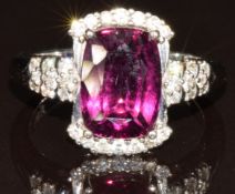 An 18k white gold ring set with a cushion cut magenta garnet and diamonds, with certificate, 6.2g,