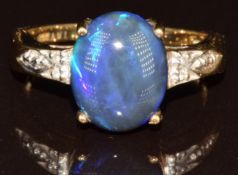 An 18k gold ring set with an oval Lightning Ridge black opal cabochon of approximately 3.7ct and