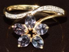 A 9k gold ring set with five oval cut colour change sapphires totalling 1ct and diamonds in the form