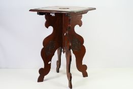A vintage folding table with carved decoration, the table top with carved Kings Regiment crest,