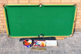 A table top snooker table, approximately 79 cm x 154 cm with cues, snooker and pool balls.