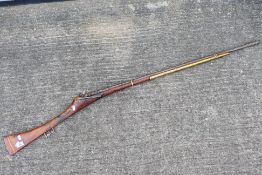 A decorative wall hanging long rifle, approximately 157 cm (l) with brackets. [W] Condition report.
