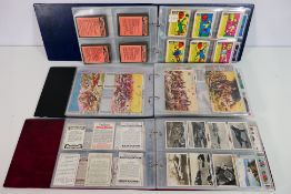 Three binders of cards to include military, cricketers, footballers, cinema stars, fish and bait,