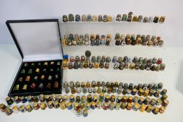 A collection of thimbles to include cloisonne, white metal, coin mounted and other.