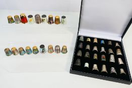 A collection of thimbles to include white metal filigree examples, enamel and other.