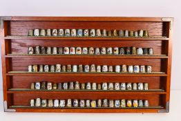 A good collection of silver plated / white metal thimbles and a wall mountable thimble display.