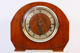 An Art Deco mantel clock, Roman numerals to a silvered chapter ring, with key and pendulum.